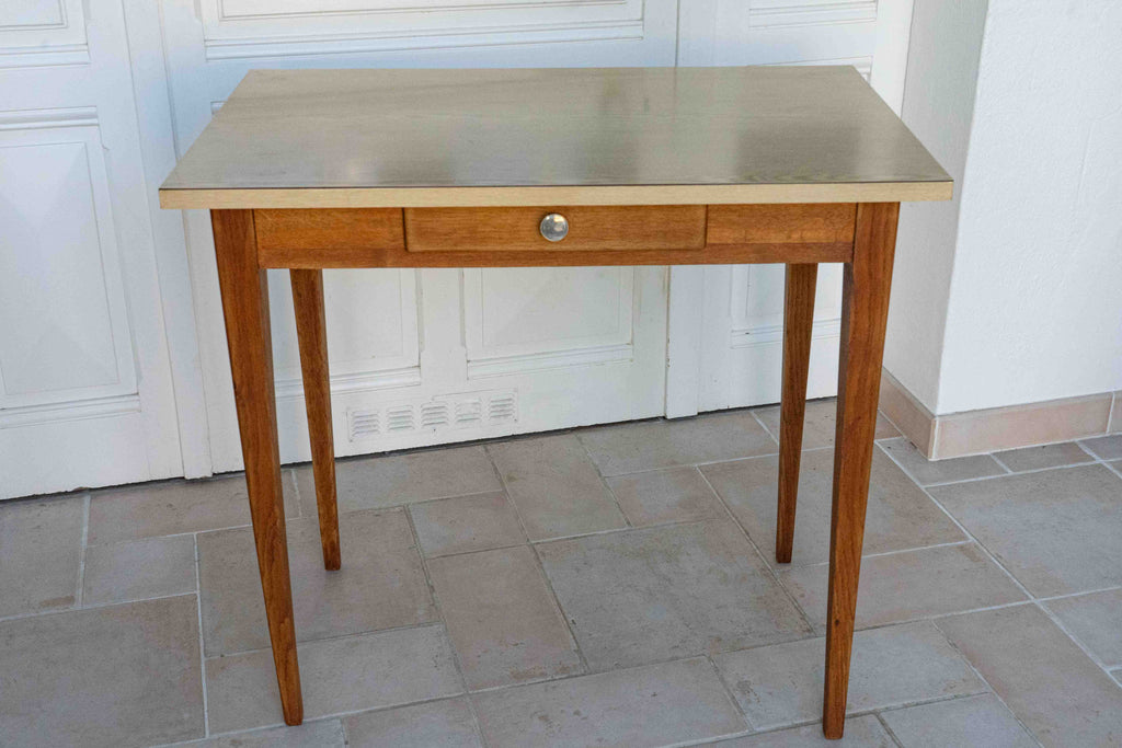 table en formica années 60 plateau beige, vue de face, dans une véranda