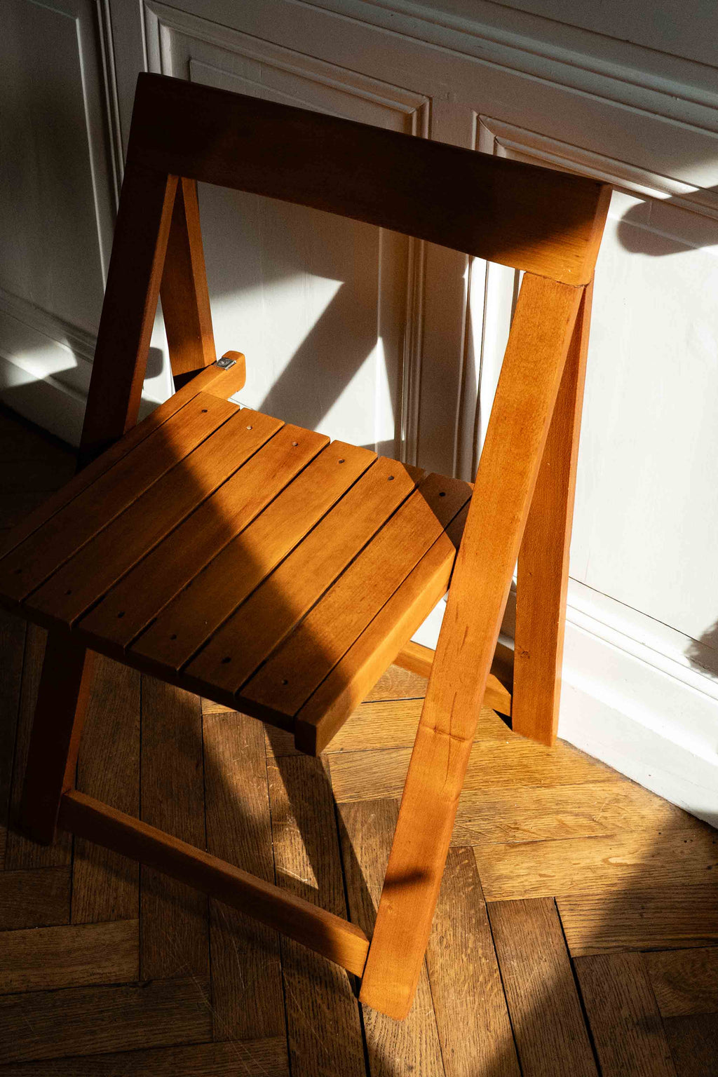 chaise pliante en bois dans une entrée, maison bourgeoise, soleil