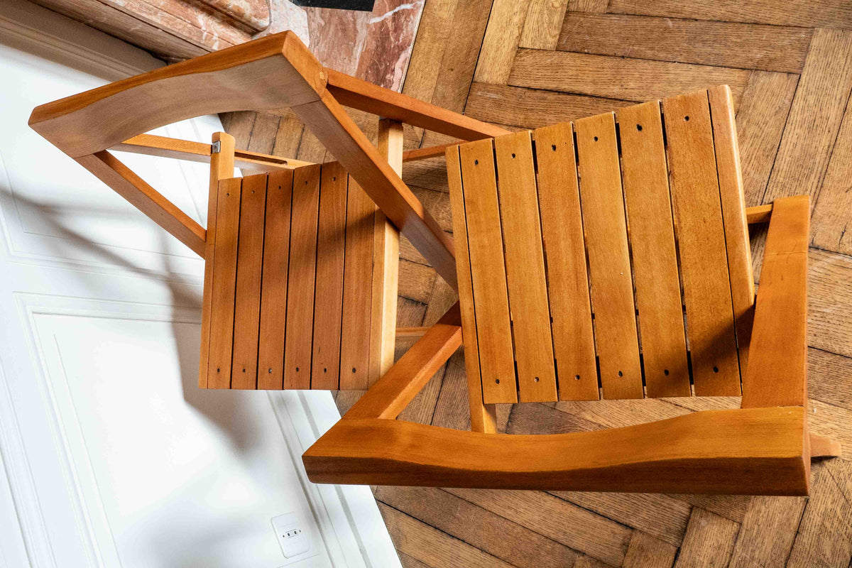 paire de chaises pliantes en bois vue du dessus dans un salon avec parquet et moulures